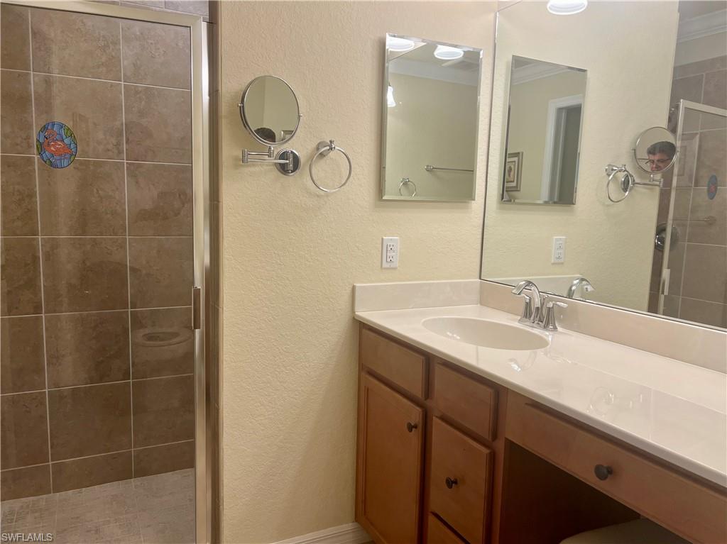 9518 Avellino Way, Unit 2313 Naples, FL 34113 - Photo 26 of 30 a bathroom with a granite countertop sink a mirror and shower