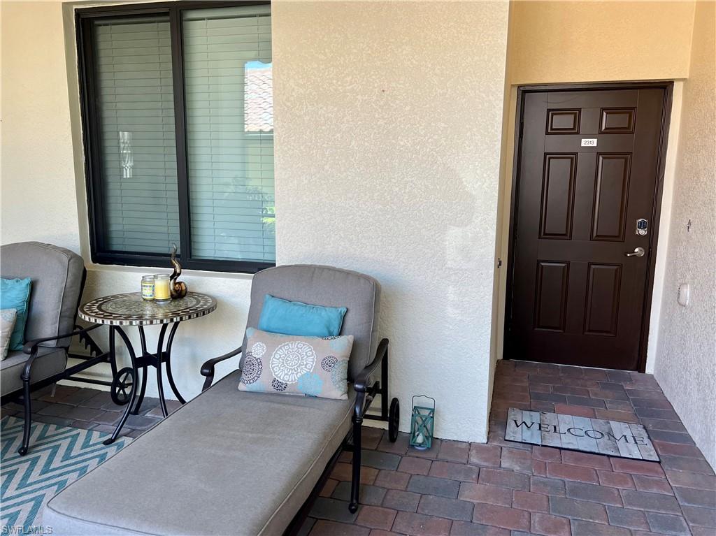 9518 Avellino Way, Unit 2313 Naples, FL 34113 - Photo 3 of 30 a balcony with table and chairs