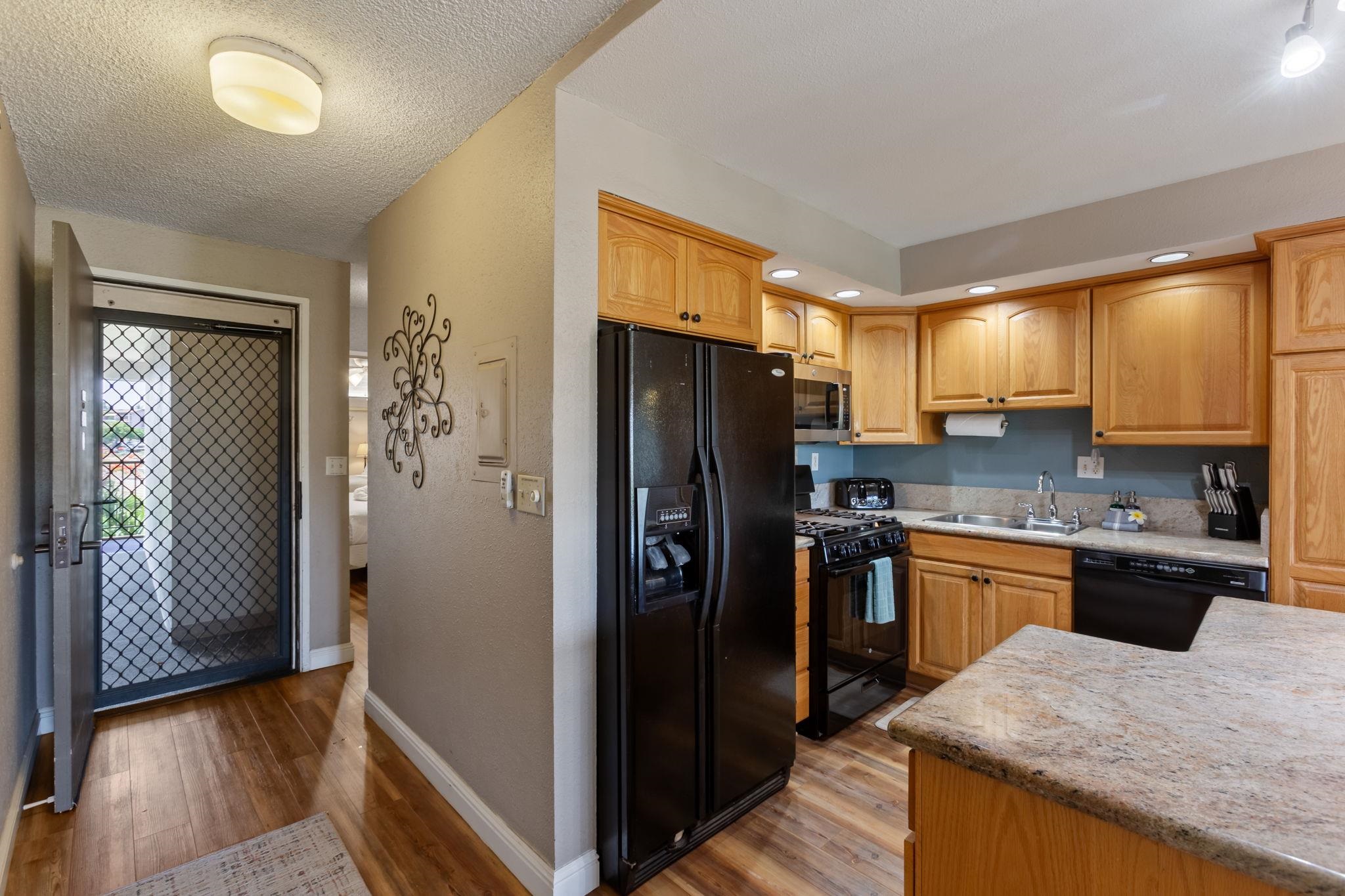 2531 South Kihei Road, Unit C414 Kihei, HI 96753 - Photo 20 of 47 a kitchen with granite countertop stainless steel appliances a refrigerator cabinets and wooden floor