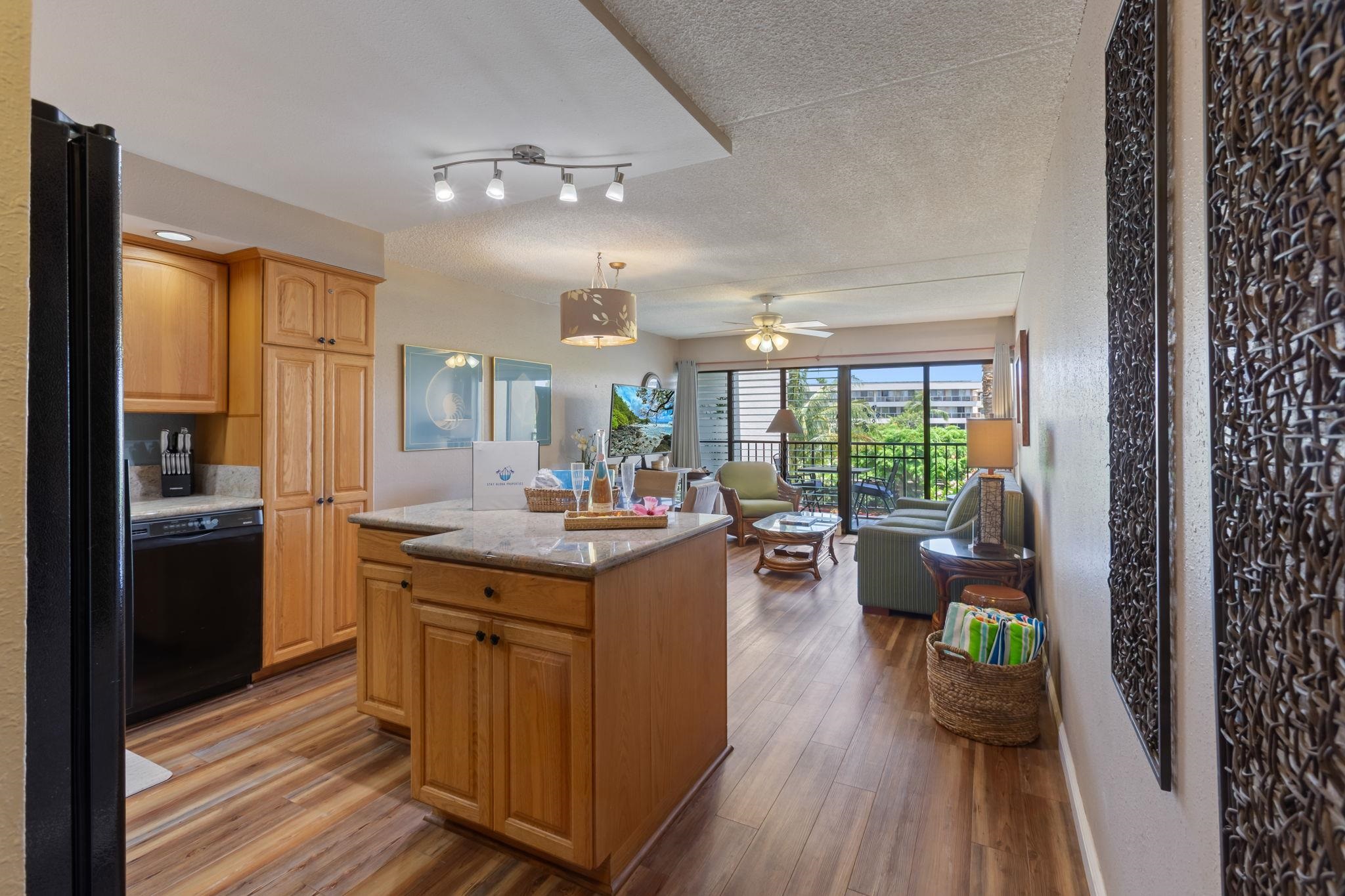 2531 South Kihei Road, Unit C414 Kihei, HI 96753 - Photo 6 of 47 a kitchen with counter space wooden floor and stainless steel appliances
