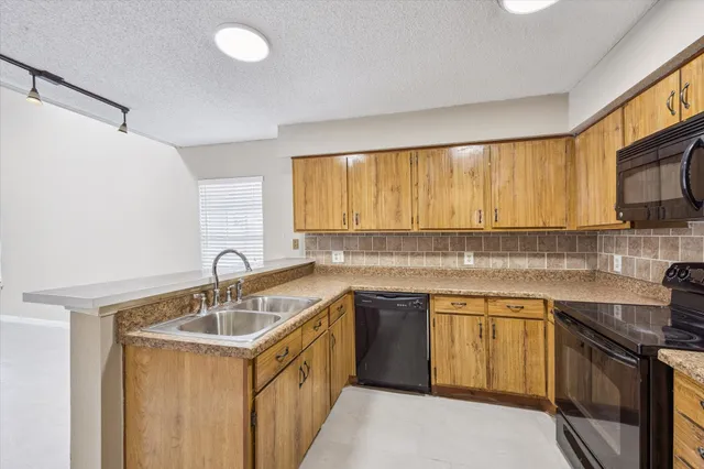 a kitchen with a sink stove top oven and cabinets