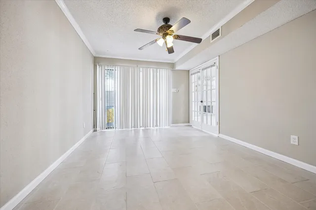 an empty room with fan and windows