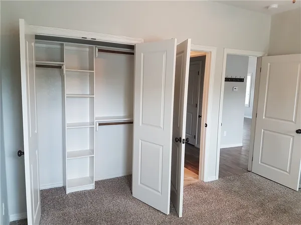 a view of a hallway with wooden floor and cabinet