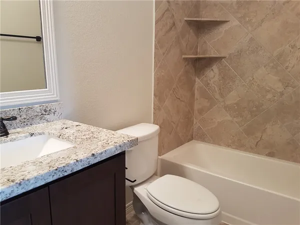 a bathroom with a granite countertop sink toilet and shower