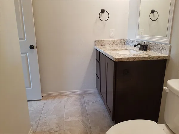 a bathroom with a granite countertop sink and a mirror
