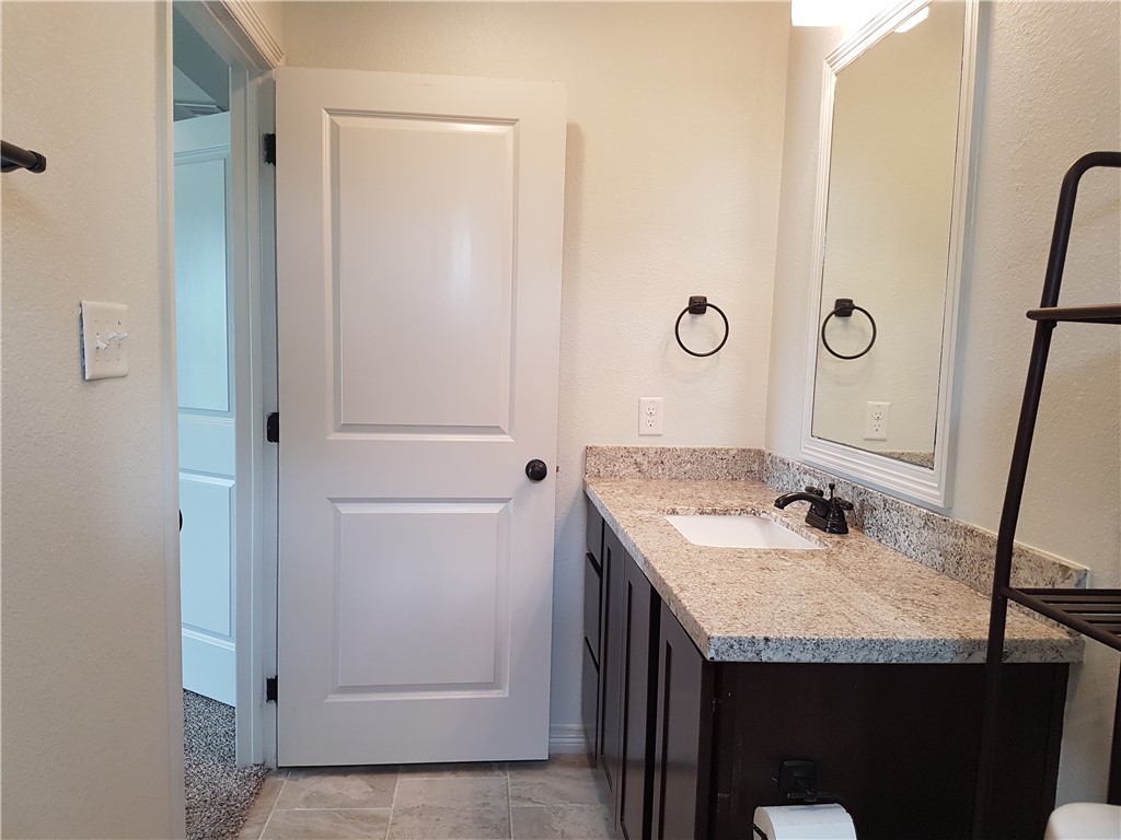 107 Ehlinger Drive Bryan, TX 77801 - Photo 29 of 50 a bathroom with a granite countertop sink and a mirror