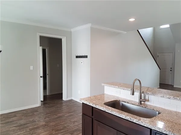 a view of a kitchen with a sink and wooden floor
