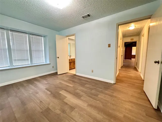 a view of a livingroom with wooden floor and a bathroom