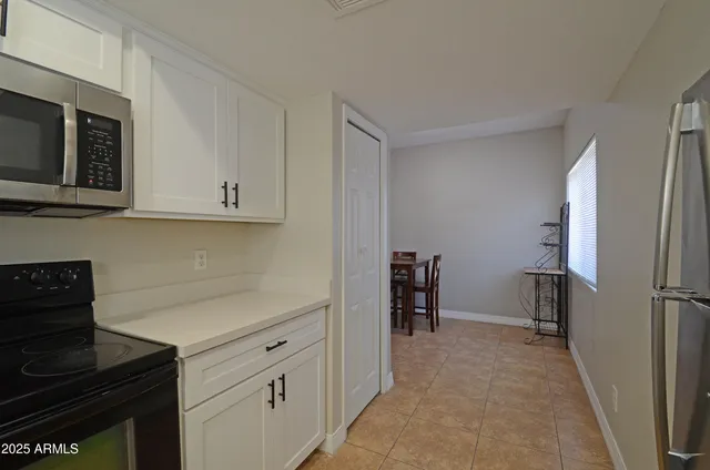 a kitchen with stainless steel appliances white cabinets and a stove top oven