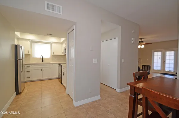 a kitchen with a refrigerator a sink dishwasher with a dining table and chairs