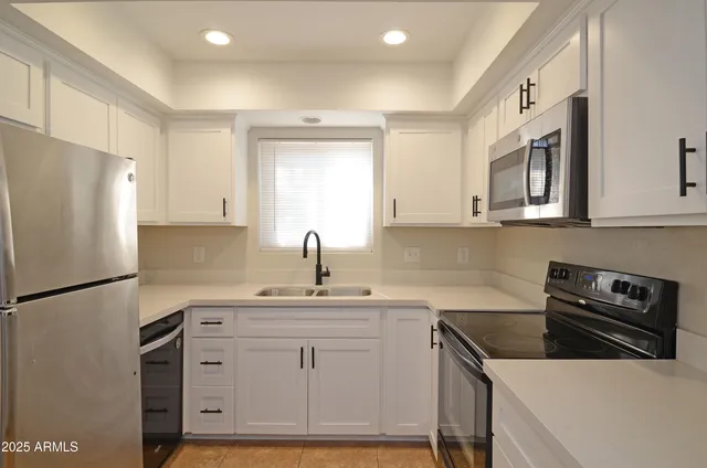 a kitchen with a sink a refrigerator and cabinets