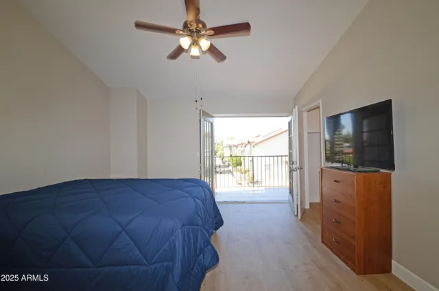 a view of a bedroom with a bed and a chandelier fan