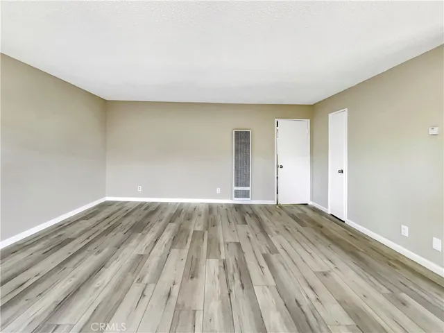 a view of an empty room and wooden floor