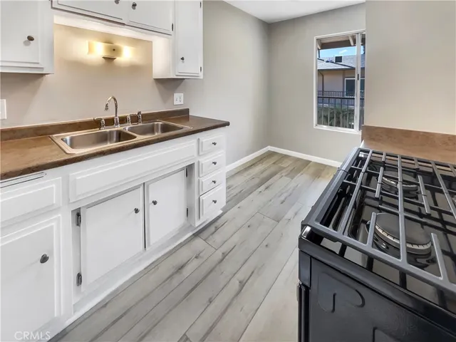 a kitchen with granite countertop a stove and a sink