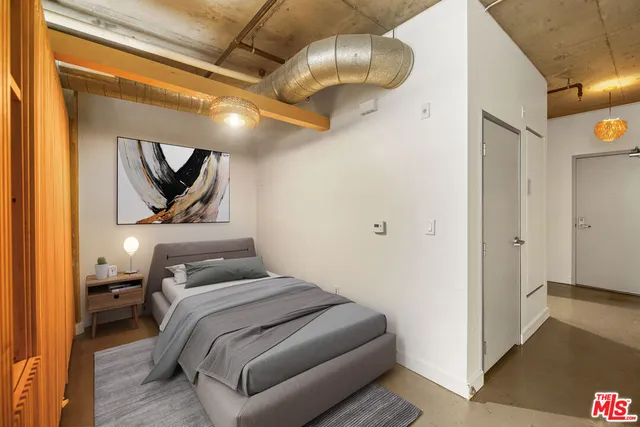 a bedroom with a bed and painting on the wall