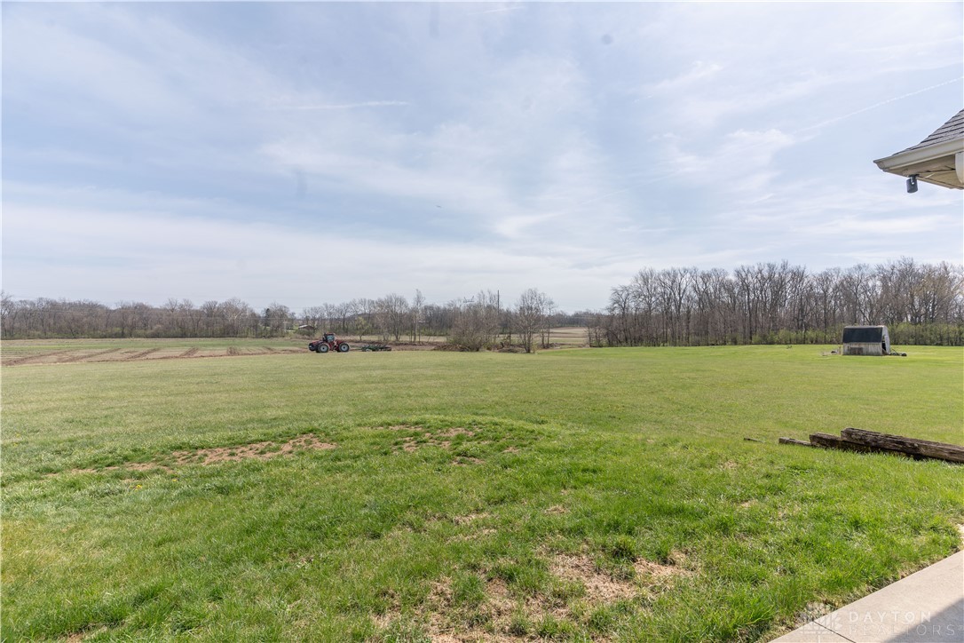 5264 Frazier-Guy Road Sidney, OH 45365 - Photo 45 of 51 Expansive green yard with ample space for outdoor activities, bordered by mature trees and a distant field.