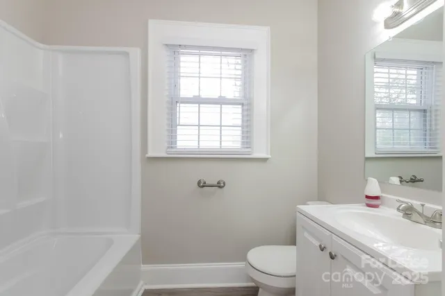 a bathroom with a sink toilet vanity and bathtub
