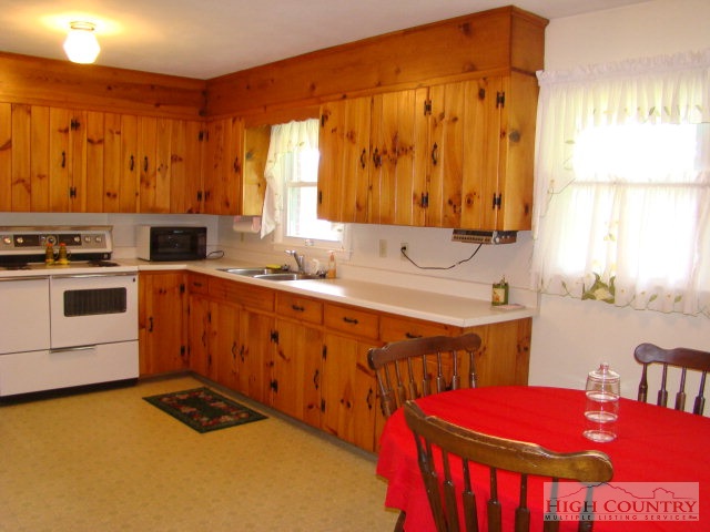 145 Wheeler Street Boone, NC 28607 - Photo 3 of 14 a kitchen that has a sink a stove top oven a counter space and a window