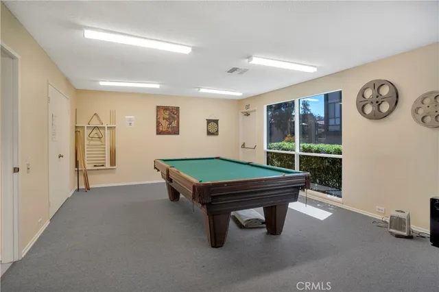 a room with pool table and windows