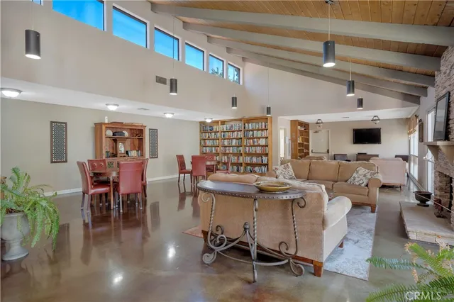 a living room with furniture kitchen view and a large window