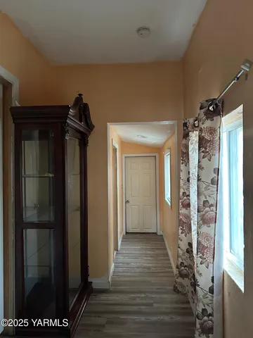 a view of a hallway with wooden floor and closet