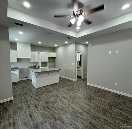 a large kitchen with kitchen island a stove a sink dishwasher and a refrigerator with wooden floor