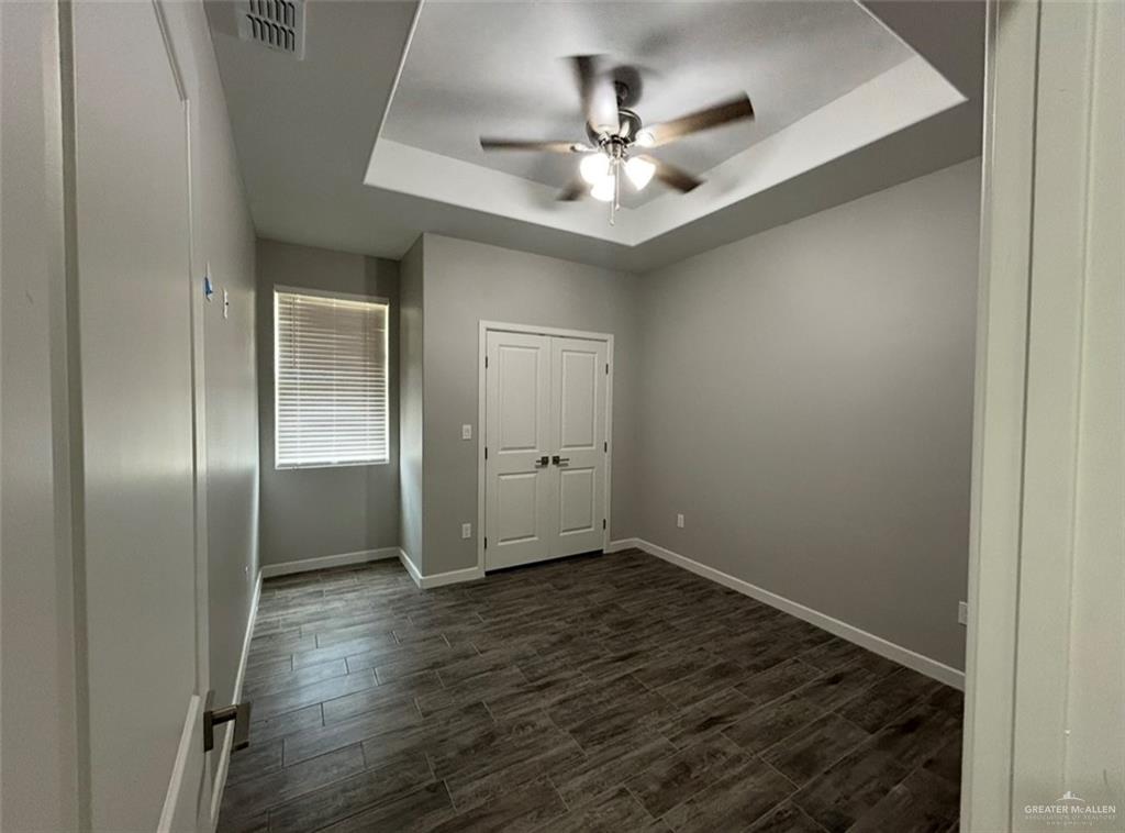 401 Bertha Avenue, Unit 2 Mission, TX 78572 - Photo 4 of 13 an empty room with wooden floor closet and chandelier fan