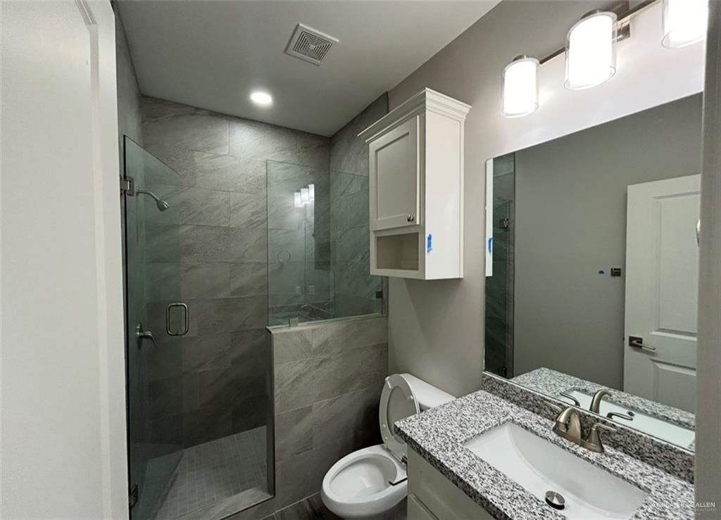 401 Bertha Avenue, Unit 2 Mission, TX 78572 - Photo 5 of 13 a bathroom with a granite countertop sink toilet and shower