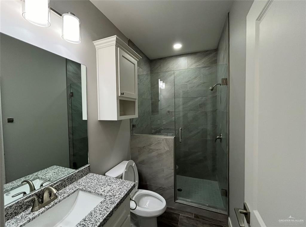 401 Bertha Avenue, Unit 2 Mission, TX 78572 - Photo 7 of 13 a bathroom with a granite countertop sink a toilet and shower