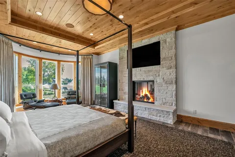 a bed sitting in a spacious bedroom next to a window