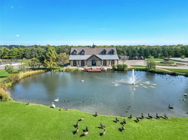 an aerial view of residential houses with outdoor space and lake view