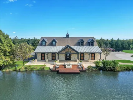 an aerial view of a house with swimming pool and lake view