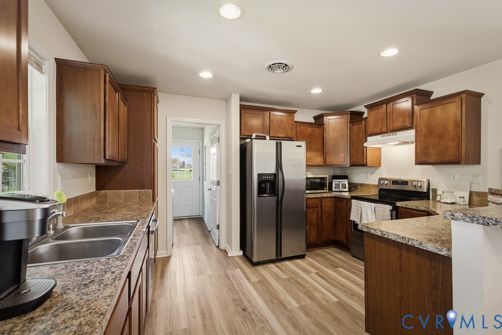 18262 Seals Road Bowling Green, VA 22427 - Photo 23 of 50 a kitchen with granite countertop stainless steel appliances a sink cabinets and a counter top space
