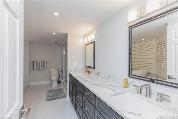 a bathroom with double vanity and a mirror