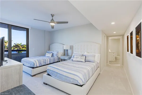 a bedroom with two beds and a chandelier