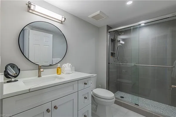 a bathroom with a sink mirror vanity and toilet