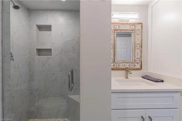 a bathroom with a shower sink and mirror