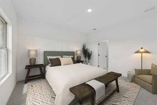 a bedroom with a bed a lamp and a rug