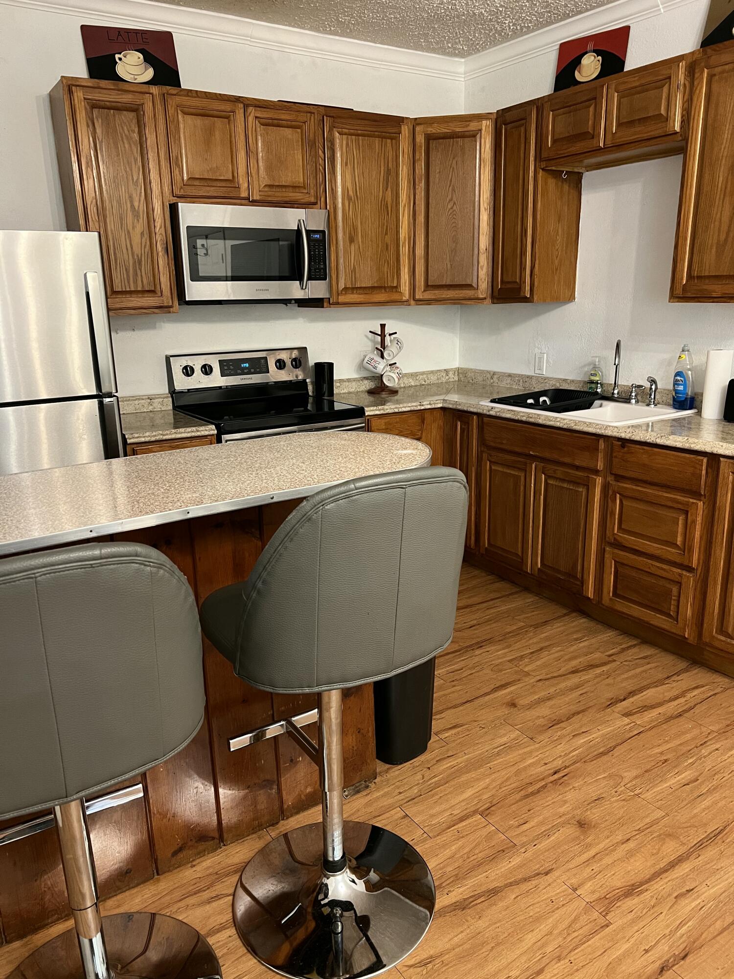 1016 Chipola Road, Unit A Fort Pierce, FL 34950 - Photo 4 of 9 a kitchen with stainless steel appliances a stove a sink cabinets and a dining table