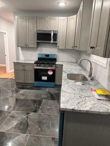 a kitchen with stainless steel appliances granite countertop a sink stove and cabinets