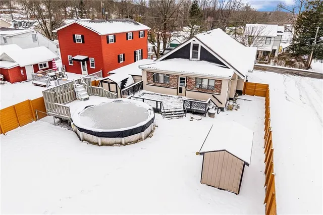 a front view of a house with swimming pool and sitting area