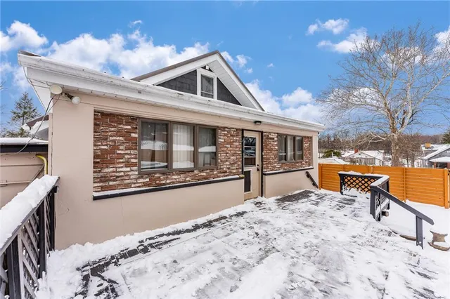 a front view of a house with large trees