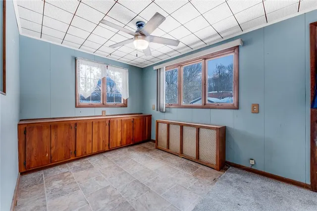 a view of an empty room with wooden floor and stairs
