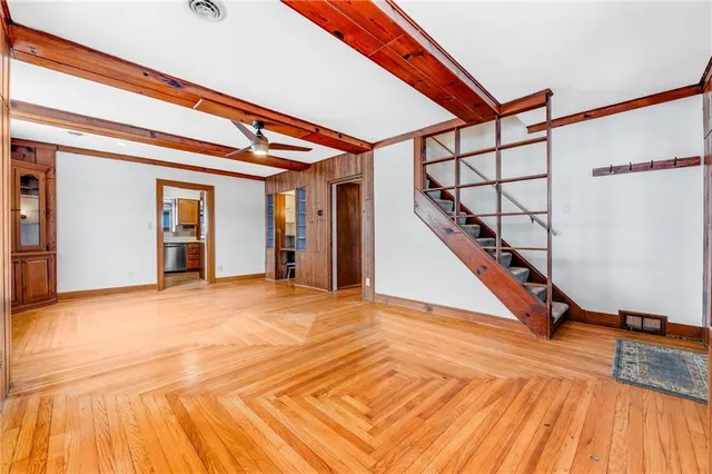 a bathroom with a toilet a sink and wooden floor