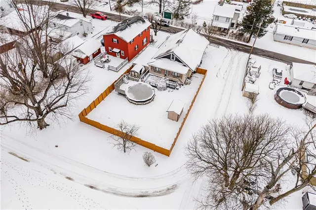 an aerial view of a house with swimming pool and large trees