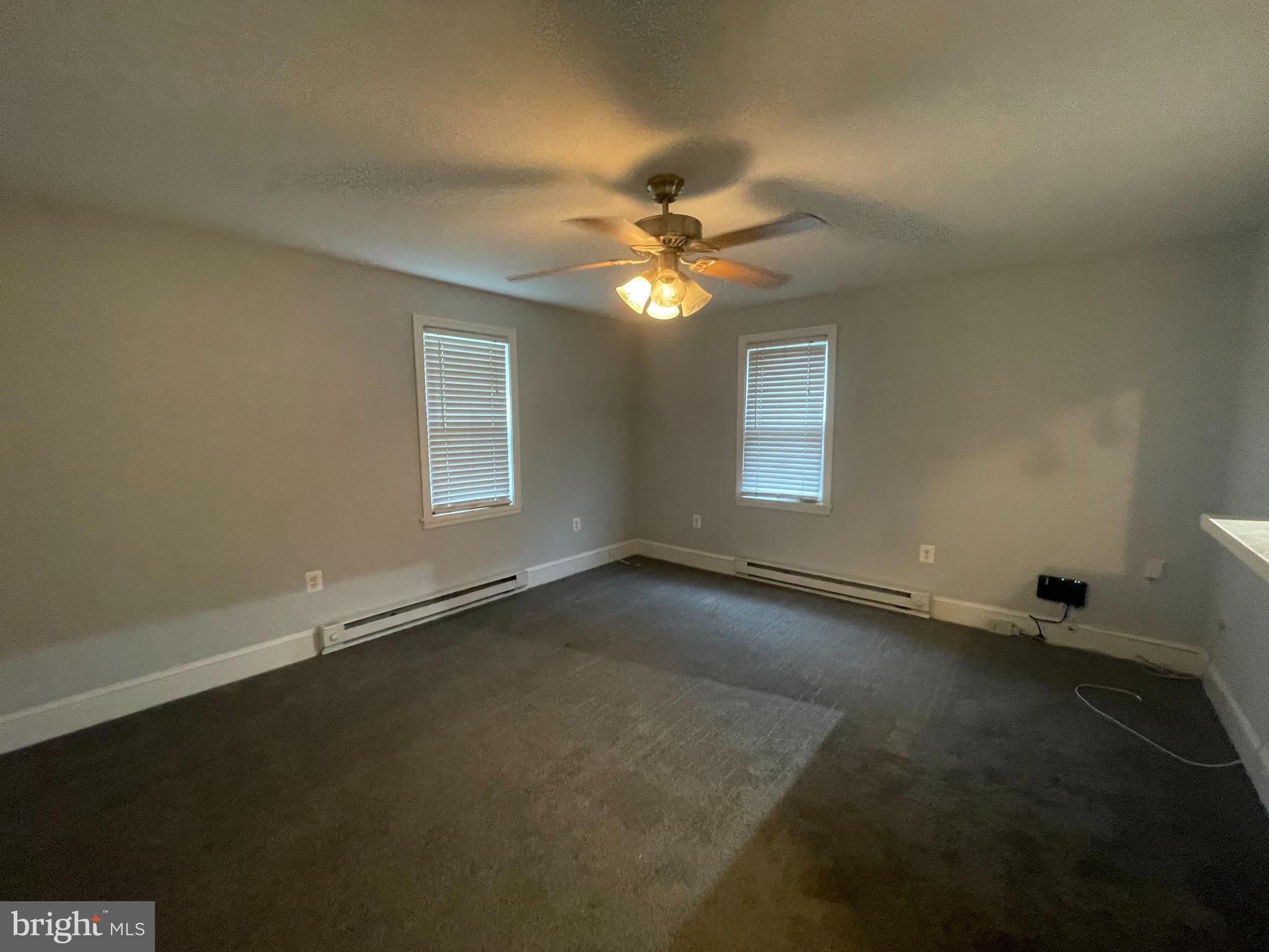 8627 1/2 Quentin Avenue Parkville, MD 21234 - Photo 2 of 11 an empty room with a window and a ceiling fan