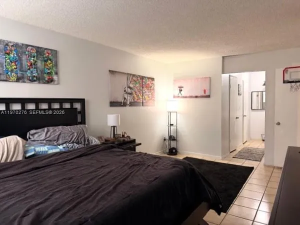a bedroom with a bed and a painting on the wall