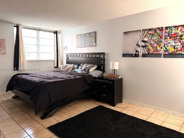a bedroom with a bed window and wall painting