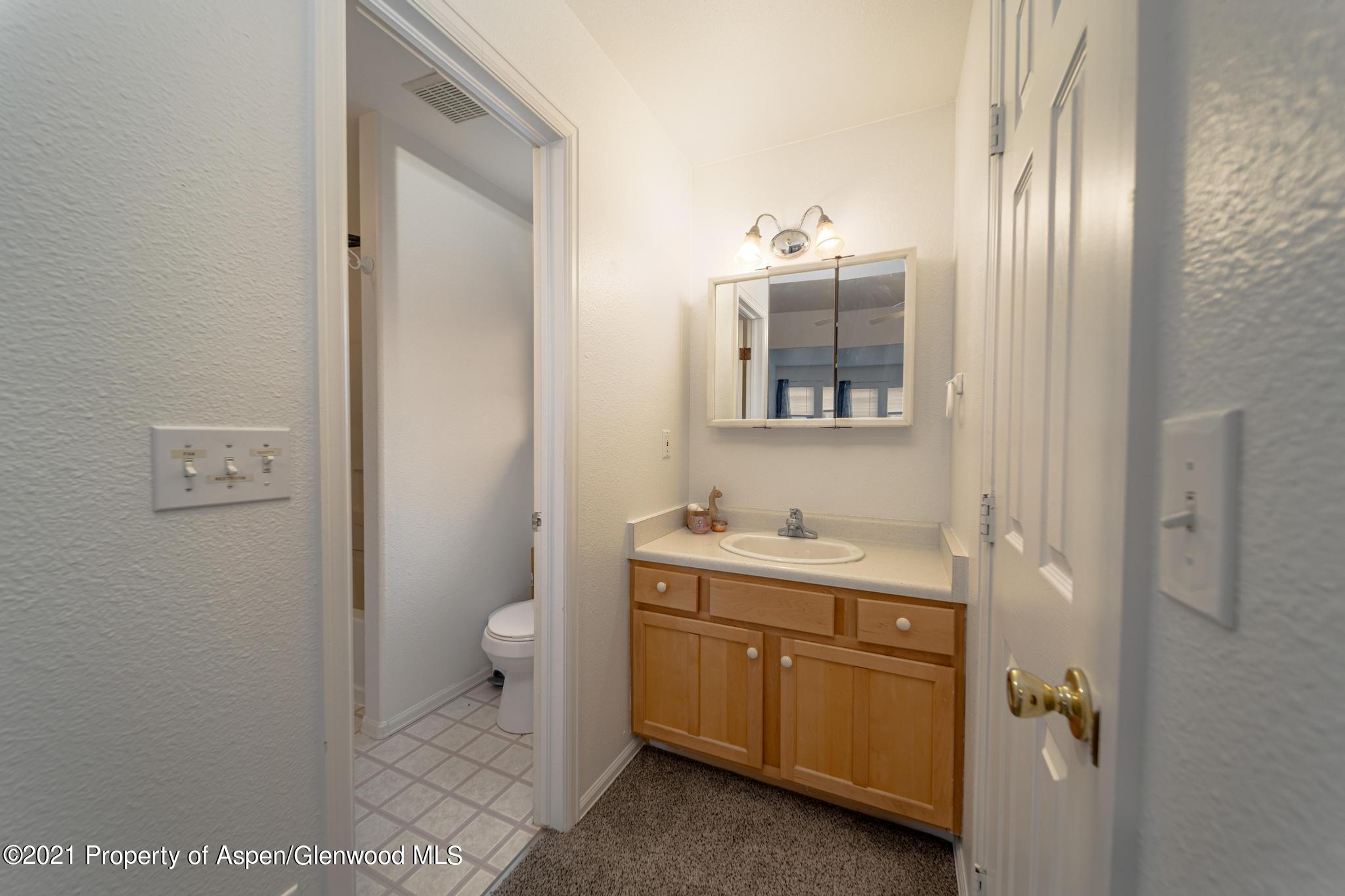 452 Evergreen Drive Rifle, CO 81650 - Photo 14 of 22 a bathroom with a toilet sink and mirror