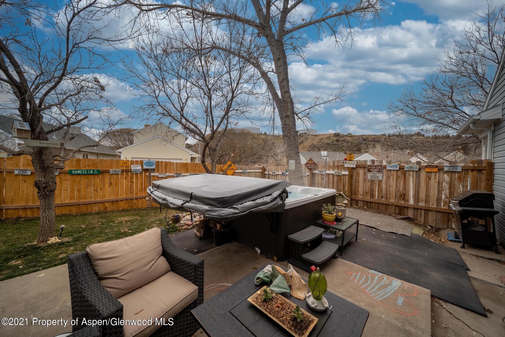 452 Evergreen Drive Rifle, CO 81650 - Photo 17 of 22 a view of a patio with table and chairs with wooden fence and plants